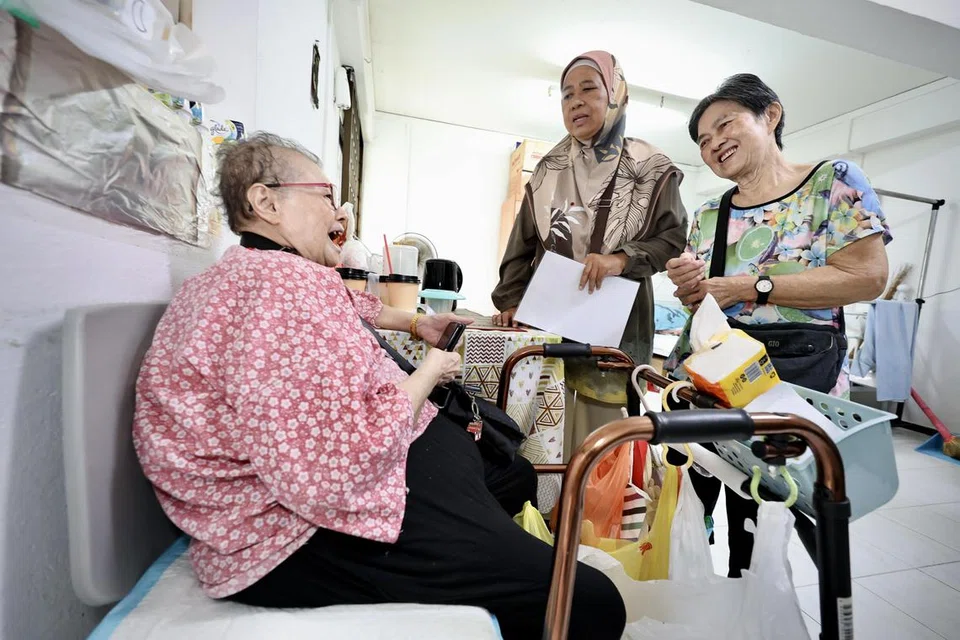 BERI SOKONGAN: Cik Sapiah Ahmad (tengah) bersama temannya, Cik Lee Boo Than (kanan), melakukan lawatan ke rumah warga emas di Blok 61 Geylang Bahru.