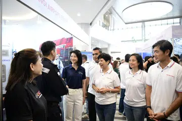 Menteri Negara Kanan Pengangkutan merangkap Pembangunan Negara, Cik Sun Xueling (tiga dari kiri); Penasihat Akar Umbi GRC Pasir Ris-Changi, Encik Sharael Taha (empat dari kiri); Menteri di Pejabat Perdana Menteri merangkap Menteri Kedua Kewangan dan Pembangunan Negara, Cik Indranee Rajah (tiga dari kanan); serta Penasihat Akar Umbi GRC Pasir Ris-Changi, Cik Valerie Lee (dua dari kanan) dan Encik Desmond Tan (kanan), berinteraksi dengan seorang majikan semasa pameran North East OneAviation Careers 2026.
