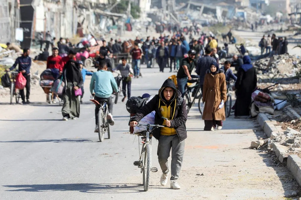Penduduk Palestin yang kehilangan tempat tinggal bergerak mencari perlindungan setelah melarikan diri dari bahagian utara Gaza di tengah operasi ketenteraan Israel, di Bandar Gaza pada 12 November.
