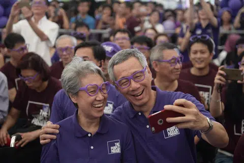 Encik Lee Hsien Loong (kanan) dan isteri, Cik Ho Ching (kiri), bergambar bersama semasa menyertai acara The Purple Parade pada 2015. Acara itu meraikan inklusiviti dan individu kurang upaya.