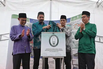 SUNTIKAN BARU MONUMEN NEGARA: (Dari kiri) Encik Masagos, Encik Rasheed, Encik Kadir dan Dr Faishal semasa melancarkan projek pemulihan dan naik taraf Masjid Jamae Chulia di masjid yang terletak di South Bridge Road itu semalam. - Foto-foto BH oleh KEVIN LIM