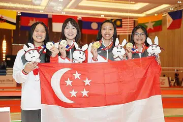 KEKALKAN KEJUARAAN: Atlet lawan pedang Singapura bagi acara Epee berpasukan wanita - (dari kanan) Filzah Hidayah Nor Anuar, Kiria Tikanah Abdul Rahman, Rebecca Ong dan Elle Koh - meraikan kemenangan mereka selepas mengalahkan Filipina. - Foto SportSG