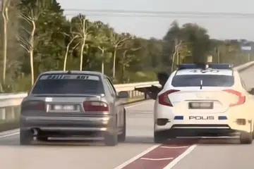 Dalam klip tular kejadian itu, polis dilihat menunjukkan mesingan untuk meminta pemandu Proton Wira itu berhenti.