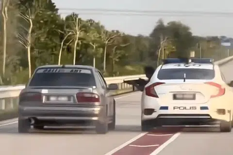 Dalam klip tular kejadian itu, polis dilihat menunjukkan mesingan untuk meminta pemandu Proton Wira itu berhenti.