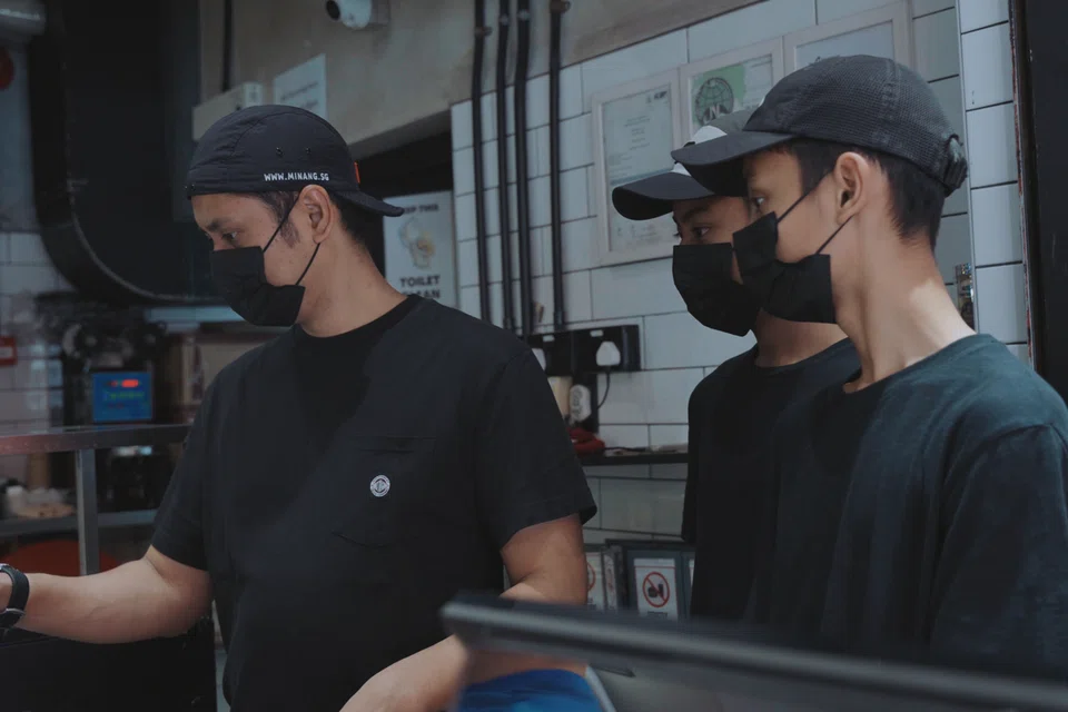 Encik Hazmi (kiri) yang sedang menggunakan sistem jualan ‘point-of-sale’ (POS) di cawangan Rumah Makan Minang di Kandahar Street. 