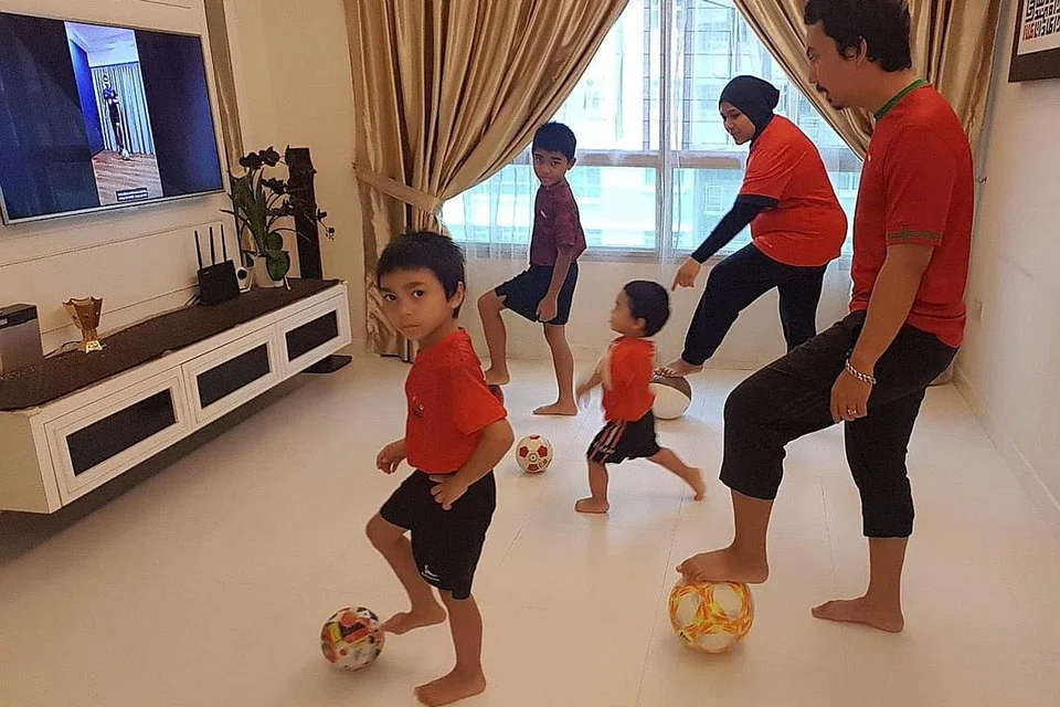 Cik Maslinda Sabtu, yang menyertai latihan dan cabaran bola sepak yang dijalani menerusi Facebook oleh Akademi Bola Sepak ActiveSG, bersama suami di rumah. - Foto ihsan CIK MASLINDA SABTU