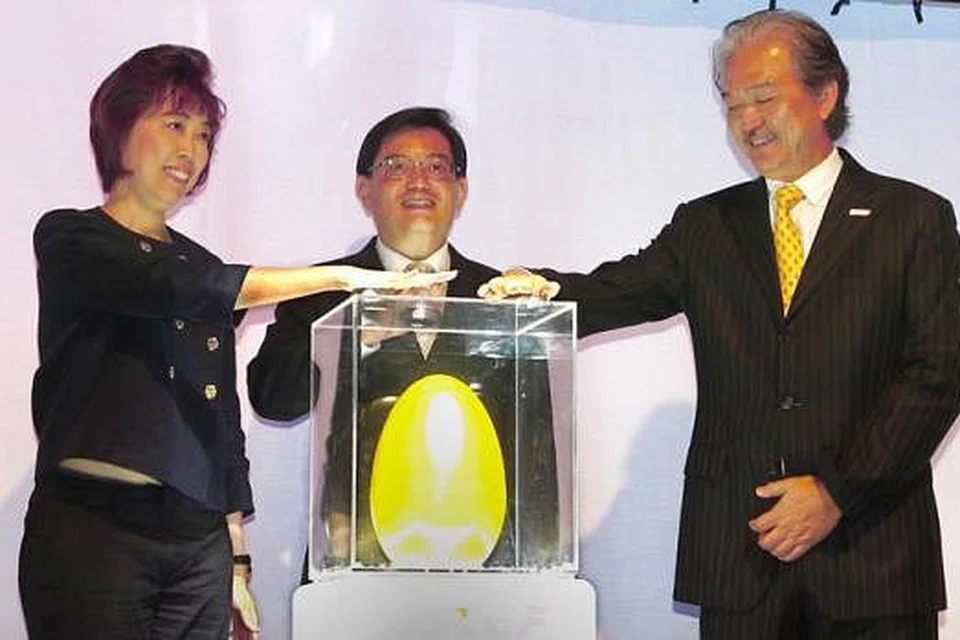 LANCARKAN KAPSUL MASA: Encik Heng (tengah), yang diapit oleh Presiden Snef, Dr Robert Yao (kanan), dan Presiden NTUC, Cik Mary Liew, sama-sama melancarkan kapsul masa yang akan dibuka semula pada 2030. Kapsul masa itu antara lain mengandungi cip bijak dan kad SD mengandungi risalah NTUC dan cetakan coklat 3D. - Foto ZAOBAO