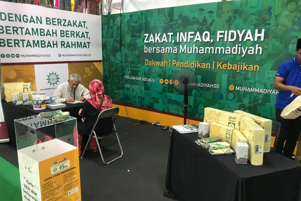 Pengunjung membayar zakat di gerai Muhammadiyah di bazar Geylang di pintu masuk Wisma Geylang Serai.
