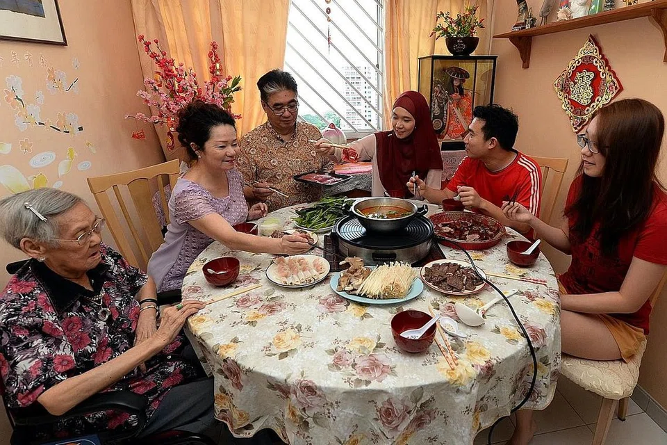 MAKAN BERSAMA: Cik Nur Jihan Li (bertudung) menjamu selera bersama keluarganya pada malam Tahun Baru Cina. Anggota keluarganya yang lain turut hadir iaitu (dari kiri) neneknya, Cik Khor Chai Loo; ibunya, Cik Lim Kim Hiang; bapanya, Encik Lee Soon Koon; suaminya, Encik Muhammad Aizat Khalis Daud; dan adiknya, Cik Li Jingrou. - Foto ZAINAL YAHYA