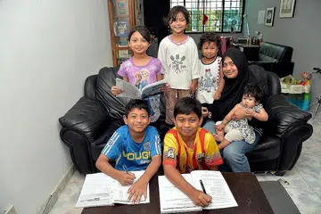 UTAMAKAN PENDIDIKAN: Cik Zabrina (bertudung hitam) lega dengan sokongan dermasiswa tambahan pemerintah yang boleh dimanfaatkan anak-anaknya pada masa hadapan. Mereka ialah (depan, dari kiri) 'Atif Fauzan, 10 tahun; 'Afif Dzakwan, 11 tahun; (belakang, dari kiri) 'Afaf Zhufairah, lapan tahun; Airis Amni Zhafirah, lima tahun; 'Adni Zhahirah, tiga tahun; dan Anis Zanirah, lapan bulan. - Foto M.O. SALLEH