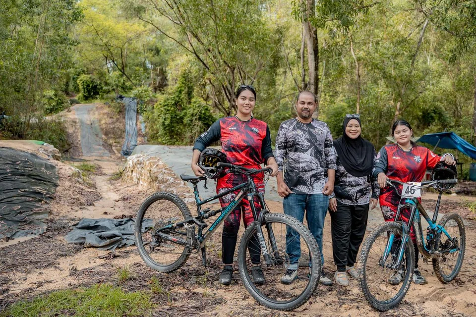 Encik Faizal Abu Bakar (dua dari kiri) dan Cik Noraslina Ramlan (tiga dari kiri) memberi sokongan penuh dalam memupuk minat anak-anak mereka Cik Nordania Khairunisa Faizal (kiri) dan Nordania Adawiah Faizal (kanan) dalam sukan berbasikal bukit. 