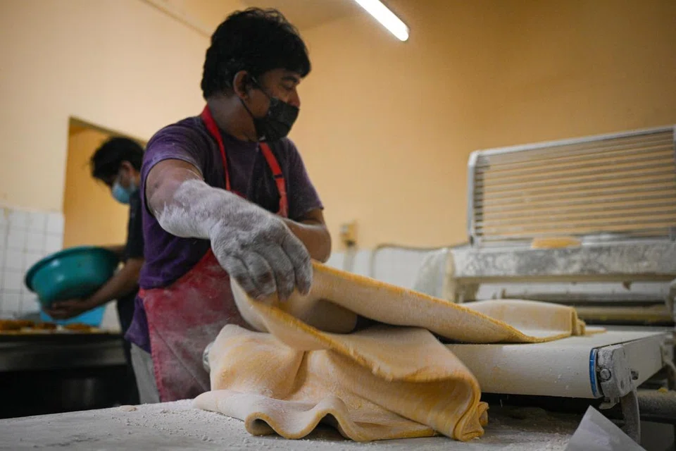 TURUN PADANG: Pengasas bersama Sha Zah Confectionery,  Encik Shariff K Abdul Majid, masih lagi bersemangat menyumbang tenaga dan membuat karipap di kedainya.