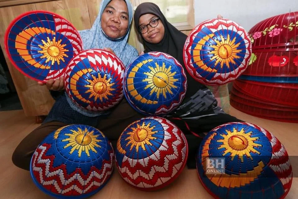 Cik Salmila (kiri) dibantu anak perempuannya, Nor Syafiqah bersama tudung saji bercorakkan Jalur Gemilang yang ditempah pelanggan mereka sempena Hari Kemerdekaan ke-67 ketika ditemui di Bandar Putra Bertam, Kepala Batas.