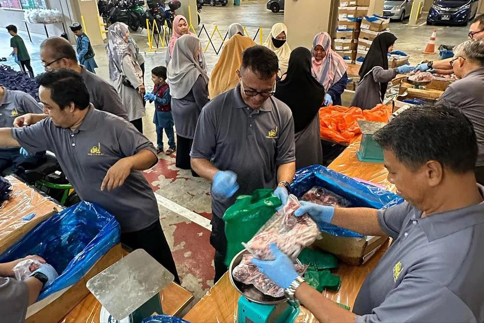 SINGSING LENGAN: Kakitangan dan sukarelawan Masjid Al-Islah di Punggol tampil menyingsing lengan pada 15 Julai bagi menyumbang masa dan tenaga membungkus semula daging korban untuk diagih kepada penerima zakat. 
