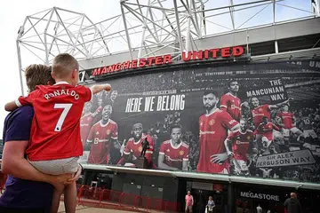 PERLU TUNJUK BUKTI VAKSINASI: (Gambar atas) Penyokong Manchester United yang ingin menyaksikan perlawanan EPL antara United dengan Newcastle pada hujung minggu ini perlu menunjukkan bukti mereka telah divaksin sepenuhnya. - Foto AFP