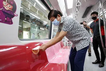 TERUS GUNA PELITUP: Encik Khaw (kiri) menekankan pentingnya pengguna pengangkutan awam menggunakan pelitup sepanjang masa memandangkan mengekalkan jarak selamat bakal menjadi mencabar semasa menaiki bas dan MRT. - Foto ZAOBAO