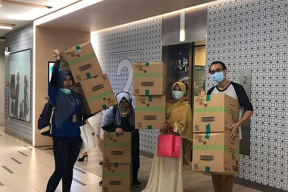 SEMANGAT SALING MEMBANTU: Beberapa warga Indonesia yang bekerja di Singapura ini membahagi- bahagikan pelitup dan snek kepada orang ramai di kawasan Payar Lebar semalam.