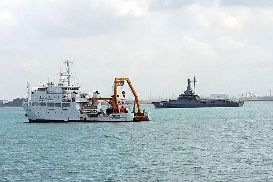 DIDAPATI MENCEROBOH: Gambar menunjukkan kapal RSS Justice (kanan) dan kapal kerajaan Malaysia MV Pedoman yang berlabuh di kawasan perairan wilayah Singapura. - Foto fail