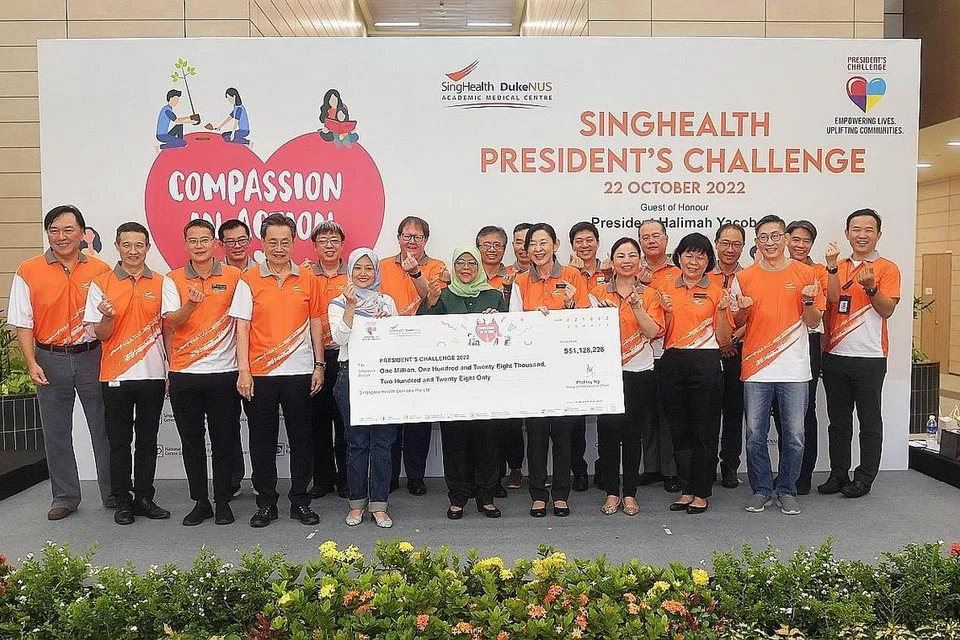 KUMPUL DANA: Cik Rahayu Mahzam (tujuh dari kiri) dan Presiden Halimah (bertudung hijau) menerima cek lebih $1.2 juta bagi Cabaran Presiden semalam oleh SingHealth. - Foto BM oleh ALPHONSUS CHERN