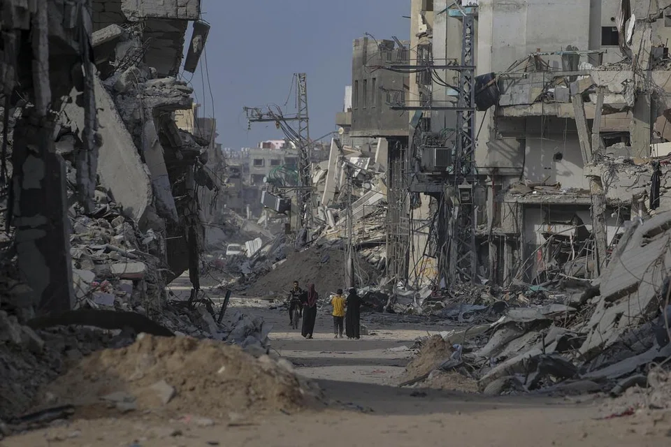 Rakyat Palestin berjalan melepasi bangunan yang musnah ketika mereka kembali ke Khan Younis selepas tentera Israel menarik keluar tentera dari selatan Jaluran Gaza, pada 30 April. Menurut Pertubuhan Bangsa-Bangsa Bersatu (PBB), ia akan mengambil masa bertahun-tahun untuk membersihkan sekitar 23 juta tan runtuhan dan senjata tidak meletup senjata yang kini bertaburan di seluruh Gaza.