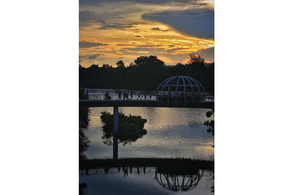 TAMAN PUNGGOL WATERWAY: Struktur berbentuk kubah di Jambatan Jewel di Taman Punggol Waterway ini dipantulkan pada permukaan air di saat akhir sebelum matahari membenam di ufuk barat. - Foto BH oleh JASON QUAH