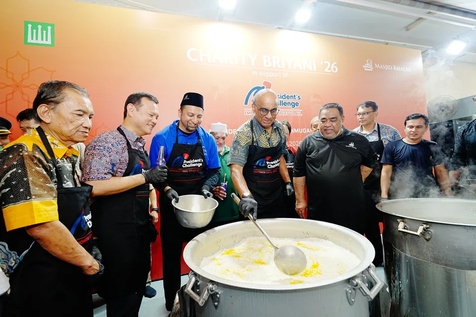 Presiden Tharman Shanmugaratnam (depan, empat dari kanan) dan Pemangku Menteri Bertanggungjawab bagi Ehwal Masyarakat Islam merangkap Menteri Negara Kanan (Pertahanan), Encik Zaqy Mohamad (depan, dua dari kiri), memberi sentuhan sendiri dalam menyediakan beriani sebelum diagihkan di Masjid Khalid pada 27 September.