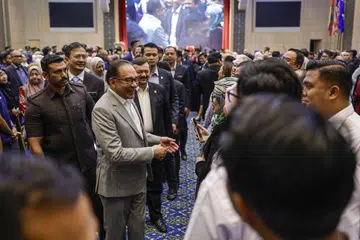 Perdana Menteri Malaysia, Datuk Seri Anwar Ibrahim (kiri), yang juga Menteri Kewangan, menyantuni warga Kementerian Kewangan pada Majlis Perhimpunan Bulanan kementerian itu pada 3 September.