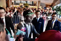SAMBUTAN MERIAH: Para peminat Liverpool yang telah berkumpul di hotel Swissotel The Stamford kelmarin memberikan sorakan yang gemuruh sejurus Sadio Mane (kiri) tiba di hotel itu. - Foto BH oleh DESMOND FOO