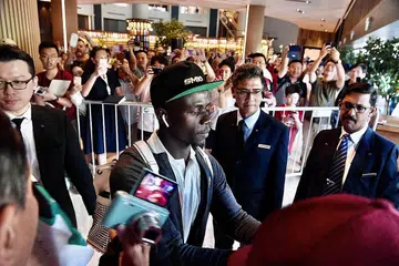 SAMBUTAN MERIAH: Para peminat Liverpool yang telah berkumpul di hotel Swissotel The Stamford kelmarin memberikan sorakan yang gemuruh sejurus Sadio Mane (kiri) tiba di hotel itu. - Foto BH oleh DESMOND FOO