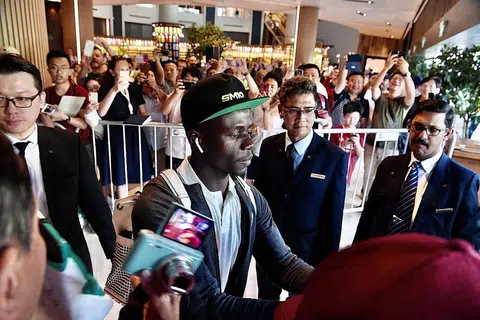 SAMBUTAN MERIAH: Para peminat Liverpool yang telah berkumpul di hotel Swissotel The Stamford kelmarin memberikan sorakan yang gemuruh sejurus Sadio Mane (kiri) tiba di hotel itu. - Foto BH oleh DESMOND FOO