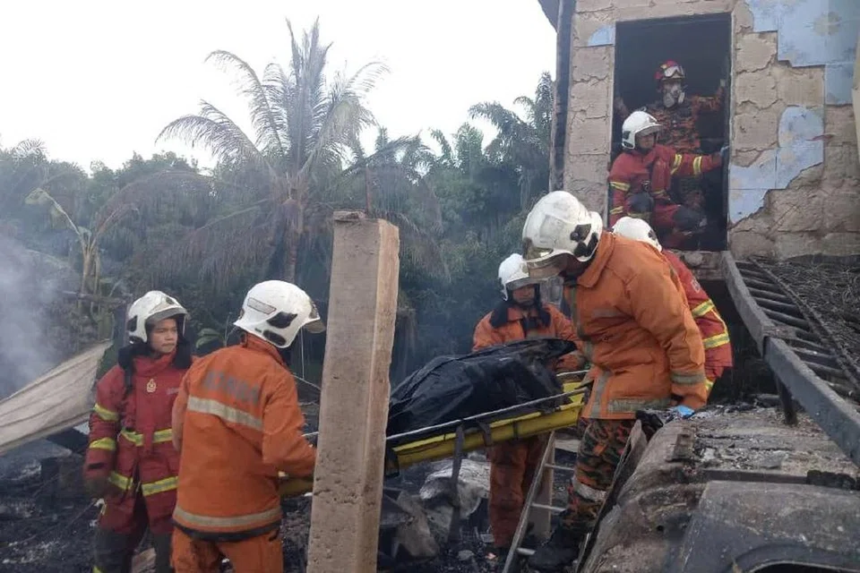 Pasukan bomba membawa keluar mangsa yang ditemui rentung di sebuah rumah di Pitas, Sabah.