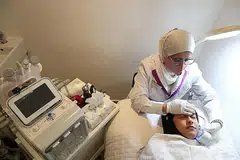 BERI RAWATAN KULIT WAJAH: Pemilik Aura Nur Spa, Cik Noraisah Noor Mohamed, menggunakan mesin sejuk untuk mengecilkan pori-pori di wajah kliennya. - Foto BH oleh TIMOTHY DAVID