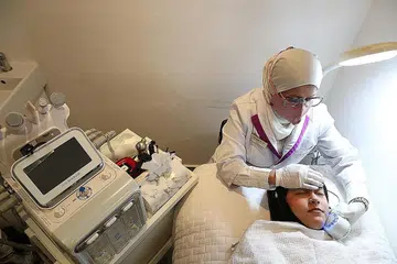BERI RAWATAN KULIT WAJAH: Pemilik Aura Nur Spa, Cik Noraisah Noor Mohamed, menggunakan mesin sejuk untuk mengecilkan pori-pori di wajah kliennya. - Foto BH oleh TIMOTHY DAVID
