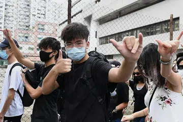 DI LUAR MAHKAMAH: Penunjuk perasaan berkumpul di luar Eastern District Courts (Mahkamah Daerah Timur) di Hongkong semalam di mana penunjuk perasaan pertama yang diberkas kerana memakai pelitup muka dihadapkan di mahkamah. - Foto AFP