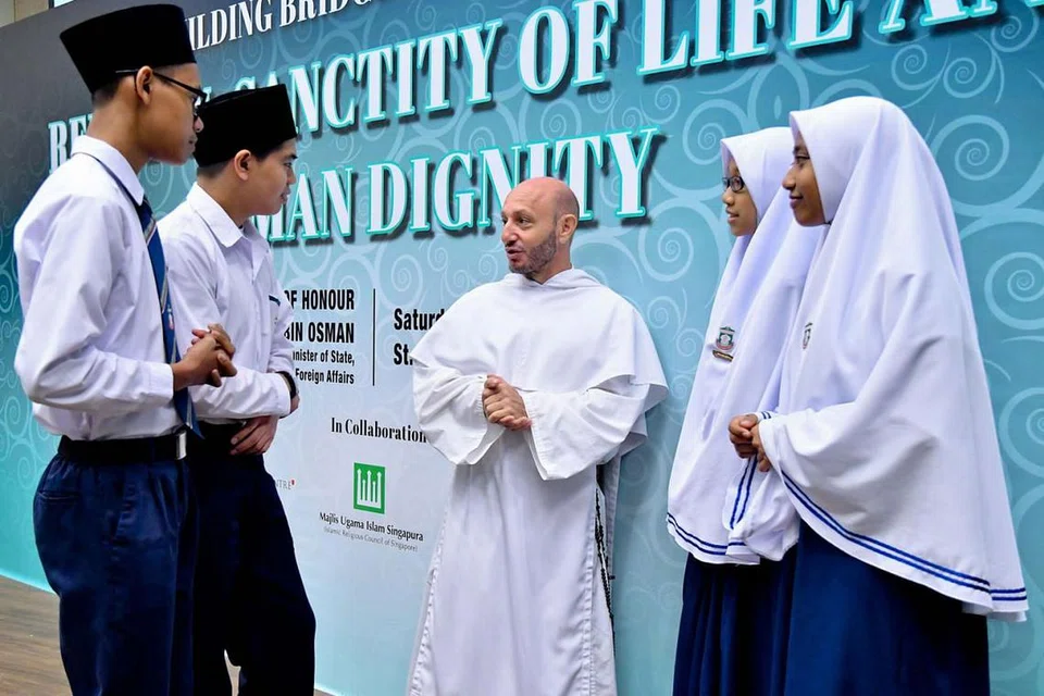 BINA JAMBATAN: Pelajar Madrasah Aljunied berpeluang berbincang dengan Rahib David Garcia dalam 'Seminar Membina Jambatan' yang diadakan di St Joseph's Institution pada Mac lalu. Umat Islam digalakkan memikirkan semula cara Muslim menganggap mereka yang bukan Muslim bagi menggalakkan pemikiran lebih inklusif. - Foto fail PUSAT HARMONI