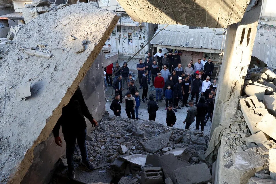 SERANGAN MENGEJUT: Penduduk  Palestin memeriksa kerosakan pada bangunan ibu pejabat Kumpulan Fatah selepas tentera Israel melancarkan serangan udara ke atas Kem Pelarian Balata, dekat Nablus, Tebing Barat, yang meragut lima nyawa, pada Sabtu.