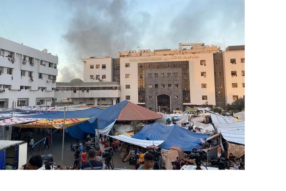 DIBOM: Asap berkepul dari bangunan hospital Al-Shifa yang sebahagian daripadanya terkena bedilan bom tentera Israel, sedang penduduk Palestin yang berlindung di situ bergegas melarikan diri, dalam kejadian pada 8 November.