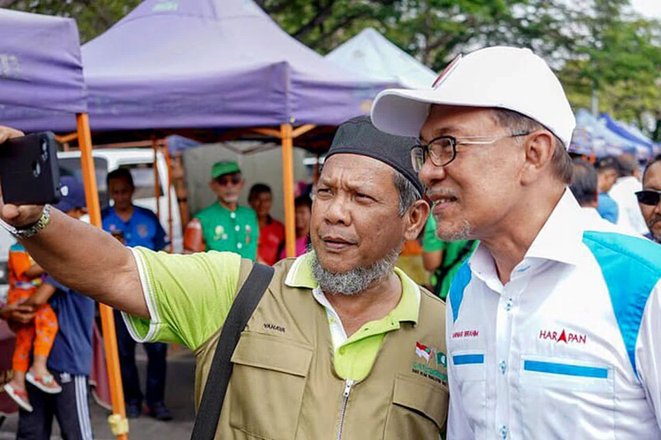 BERGAMBAR SAMA: Seorang penduduk di Port Dickson sempat 'berselfie' dengan Datuk Seri Anwar (kanan) yang kini gigih berkempen menjelang pilihan raya kecil di kawasan itu. - Foto TWITTER