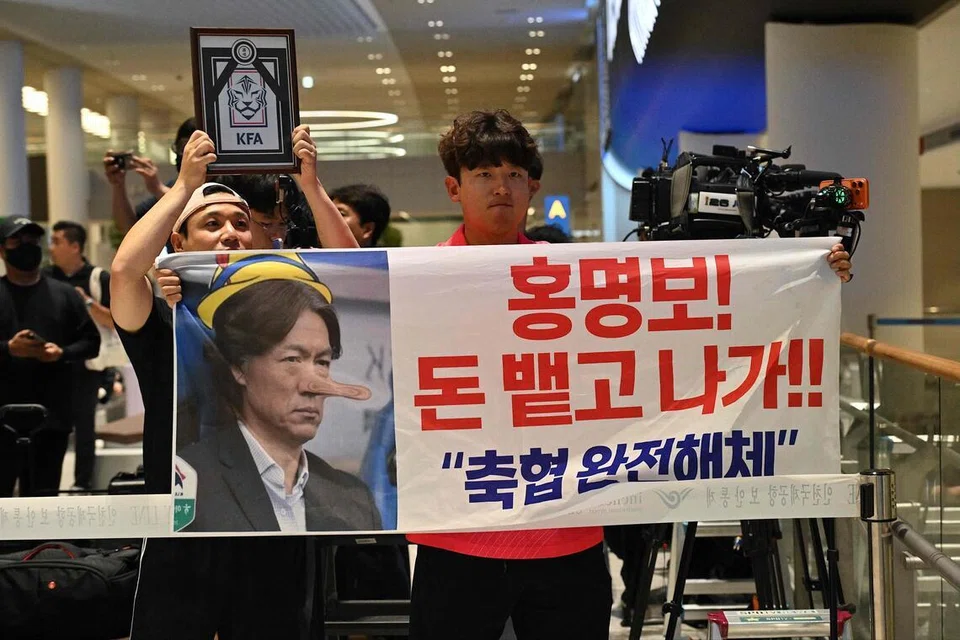 Seorang lelaki memegang sepanduk bertulis “Hong Myung-bo! Pulangkan wang itu dan keluar! Bubarkan KFA” ketika menunggu ketibaan jurulatih Korea Selatan, Hong Myung-bo, di Lapangan Terbang Antarabangsa Incheon di Seoul pada 30 Jun 2026. Hong mengumumkan peletakan jawatan selepas Korea Selatan tersingkir di peringkat kumpulan Piala Dunia FIFA 2026, ketika kemarahan rakyat terhadap Persatuan Bola Sepak Korea (KFA) terus memuncak dan mencetuskan tuntutan reformasi besar-besaran dalam pengurusan bola sepak negara itu.