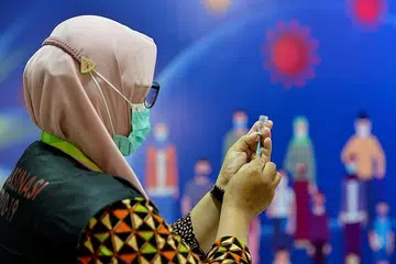 VAKSIN SINOVAC BAGI INDONESIA: Seorang pekerja kesihatan Hospital Zainoel Abidin di Banda Aceh bersiap sedia memberikan vaksin Sinovac buatan China. Pertubuhan Kesihatan Sedunia merancang meluluskan beberapa vaksin termasuk dari China dalam beberapa bulan mendatang. - Foto AFP