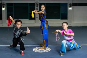 PERSEMBAHAN CEMERLANG: (Dari kiri) Lucas Teo, Kassandra Ong dan Tan Hui En antara anggota pasukan Singapura yang meraih pingat emas dalam Kejohanan Wusyu Muda Asia.