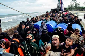 Pelarian Rohingya yang baru sampai memerhati dari atas bot selepas pihak berkuasa menghalang mereka daripada turun dan mengarahkan mereka kekal berada di atas kapal, di Pantai Leuge, wilayah Aceh, Indonesia pada 29 Januari 2025. Menurut pegawai tempatan, sekurang-kurangnya 75 pelarian sampai dengan bot di pantai pelancongan itu, namun tidak dibenarkan mendarat oleh pihak berkuasa.
