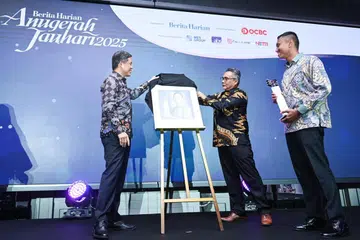 Menteri Penyelaras bagi Perkhidmatan Awam merangkap Menteri Pertahanan, Encik Chan Chun Sing (kiri), dan Editor Berita Harian, Encik Nazry Mokhtar (tengah), mengetengahkan potret penerima Anugerah Jauhari 2025, Panglima Divisyen Kesembilan (9 Div) dan Ketua Pegawai Infantri Angkatan Bersenjata Singapura (SAF), Brigedier Jeneral (BG) Fairoz Hassan (memegang trofi). 