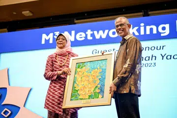 PENGHARGAAN BUAT PRESIDEN: Encik Masagos Zulkifli Masagos Mohamad menyampaikan cederahati lukisan batik kepada Presiden Halimah Yacob tanda penghargaan bagi bakti beliau kepada masyarakat Melayu/Islam dan negara.
