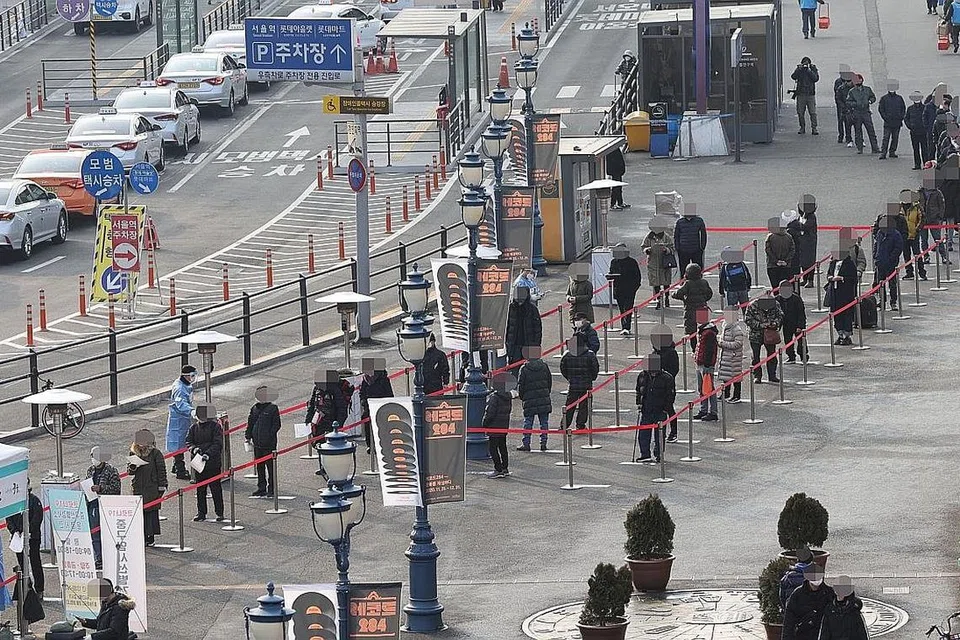 KES JANGKITAN TERUS TINGGI: Penduduk Seoul di Korea Selatan beratur panjang untuk mengambil ujian Covid-19 di pusat ujian sementara di luar Stesen Seoul semalam. - Foto EPA-EFE