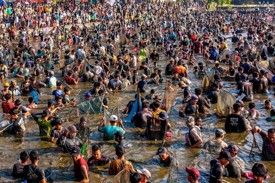 Penduduk menangkap ikan di sebuah kolam sempena tradisi ‘memet ikan’ di daerah Kalikotes, Klaten, Jawa Tengah, pada 19 Julai lalu.  Indonesia merekodkan jumlah penduduk melepasi 290 juta orang dengan hampir 70 peratus berada dalam usia produktif, sekali gus memberi peluang besar untuk memacu pertumbuhan ekonomi negara.