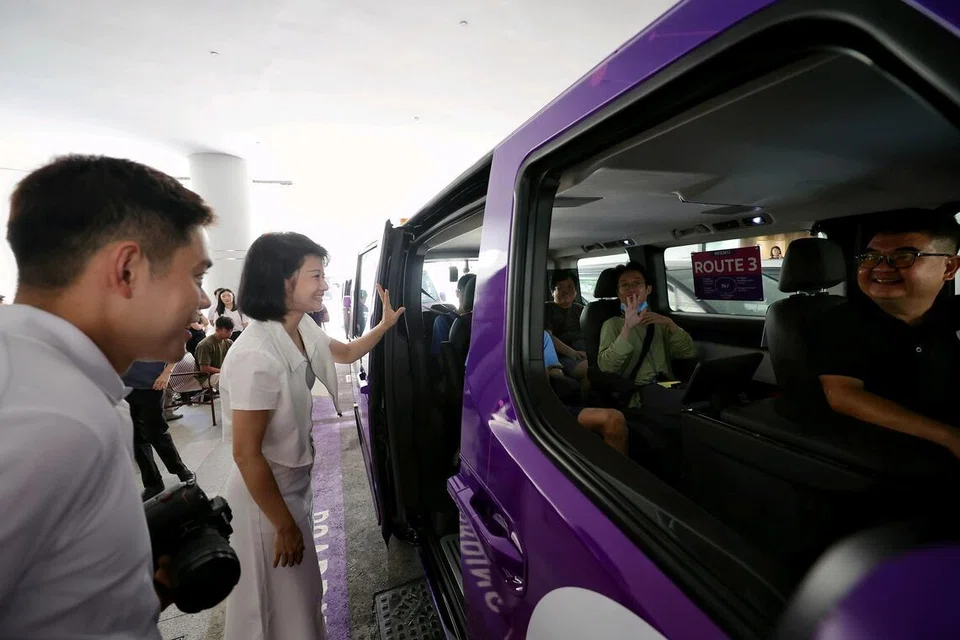 Menteri Negara Kanan (Pengangkutan merangkap Pembangunan Negara), Cik Sun Xueling (tengah), bertemu dengan beberapa penumpang yang teruja menaiki kenderaan ulang-alik pandu sendiri pada pagi 1 April di Pusat Membeli-belah Punggol Coast.