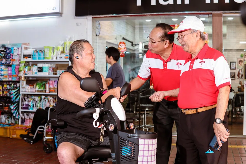 Bakal calon Parti Kemajuan Singapura (PSP), Encik Jeffrey Khoo (dua dari kanan), dan Dr Tan Cheng Bock (kanan), berbual dengan penduduk yang berkerusi roda semasa lawatan di pusat beli-belah Bishan North pada 17 April. 