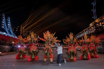 INSPIRASI DARI CEMPAKA: Encik Ragitya Firstatama (tengah) mengambil inspirasi daripada bunga cempaka bagi rekaan kostum untuk kontinjen penari Melayu dalam perarakan Chingay 2024. Unsur-unsur bunga ini, seperti kelopaknya, boleh dilihat pada hiasan kepala dan juga bahagian belakang kostum.