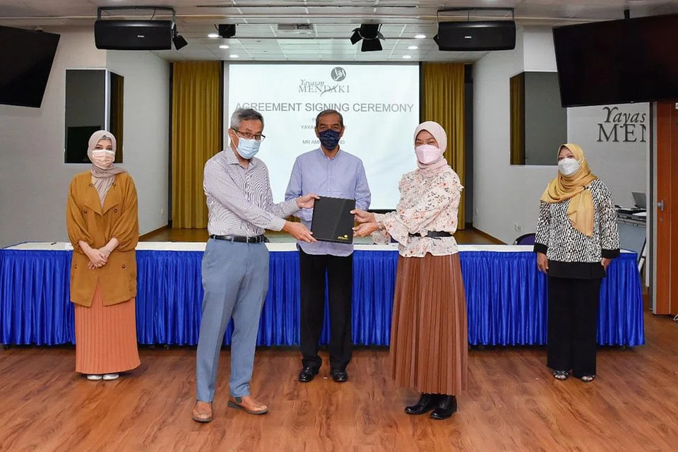 HULURKAN SUMBANGAN: (Dari kiri) Cik Sharifah Farhana Tahir Al-Hadad; Encik Amran Mohd; Encik Abdul Razak Maricar; Cik Zuraidah Abdullah dan Cik Zulaiha Yusuf, di majlis tandatangani perjanjian antara Mendaki dengan Encik Amran baru-baru ini.- Foto YAYASAN MENDAKI